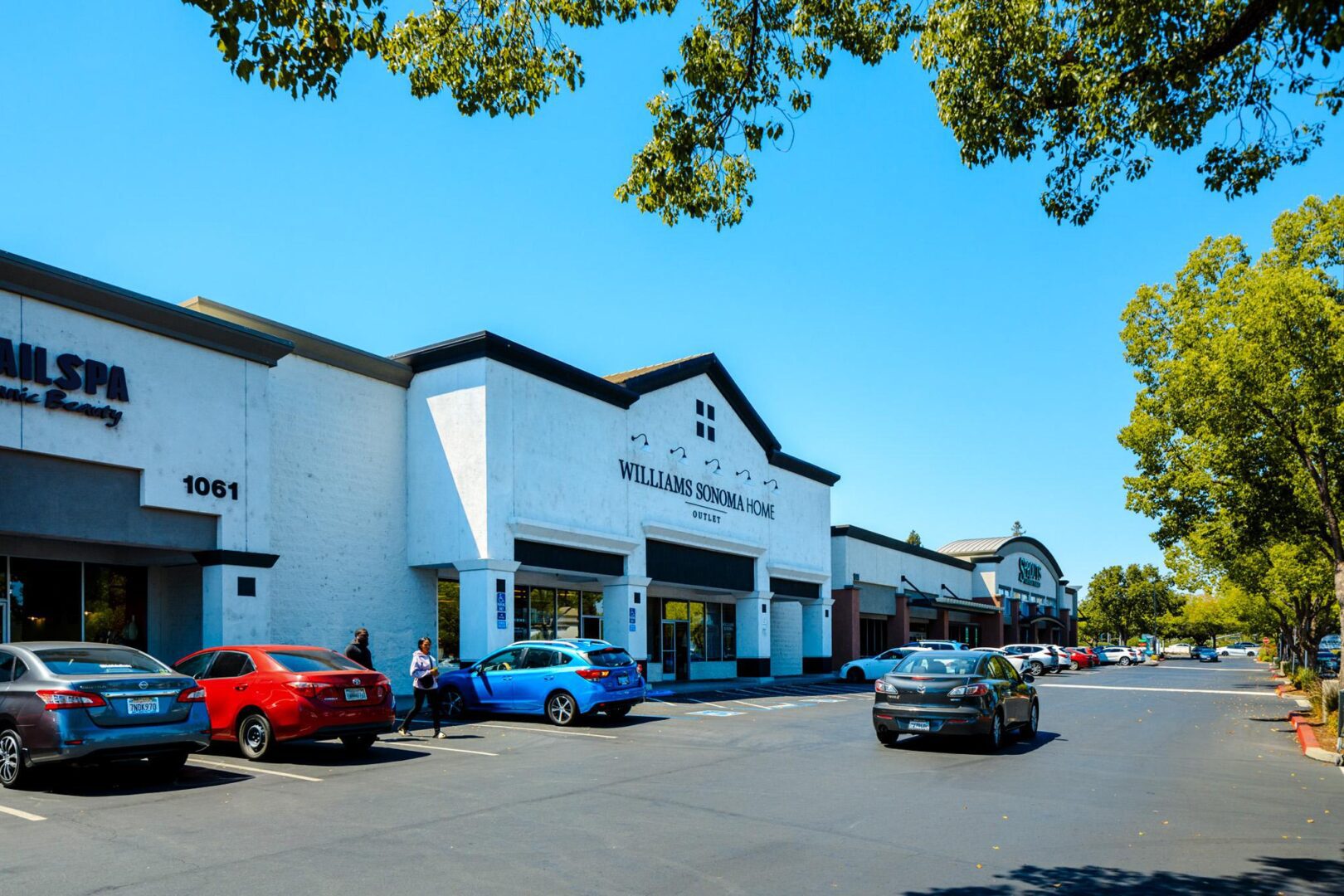 A large white building with cars parked in front of it.