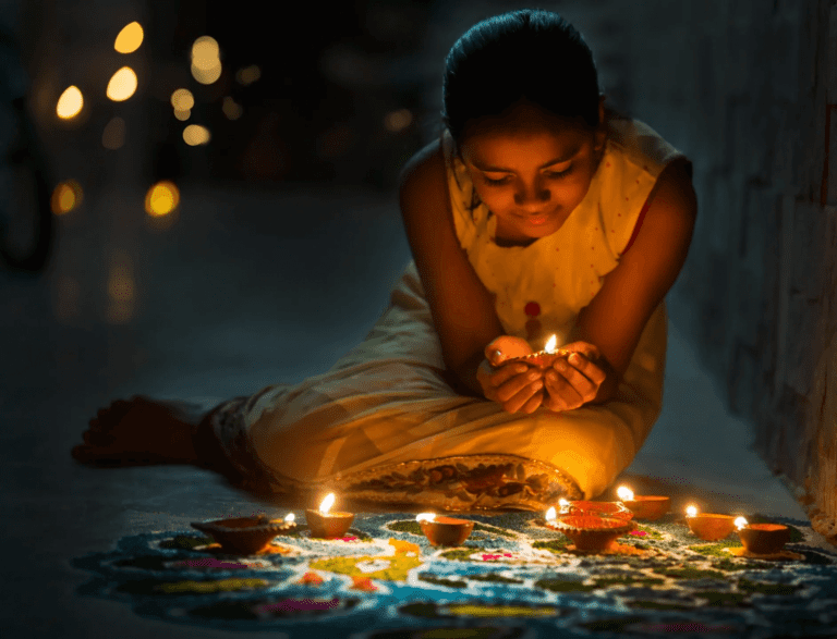 A girl is sitting on the ground with candles.