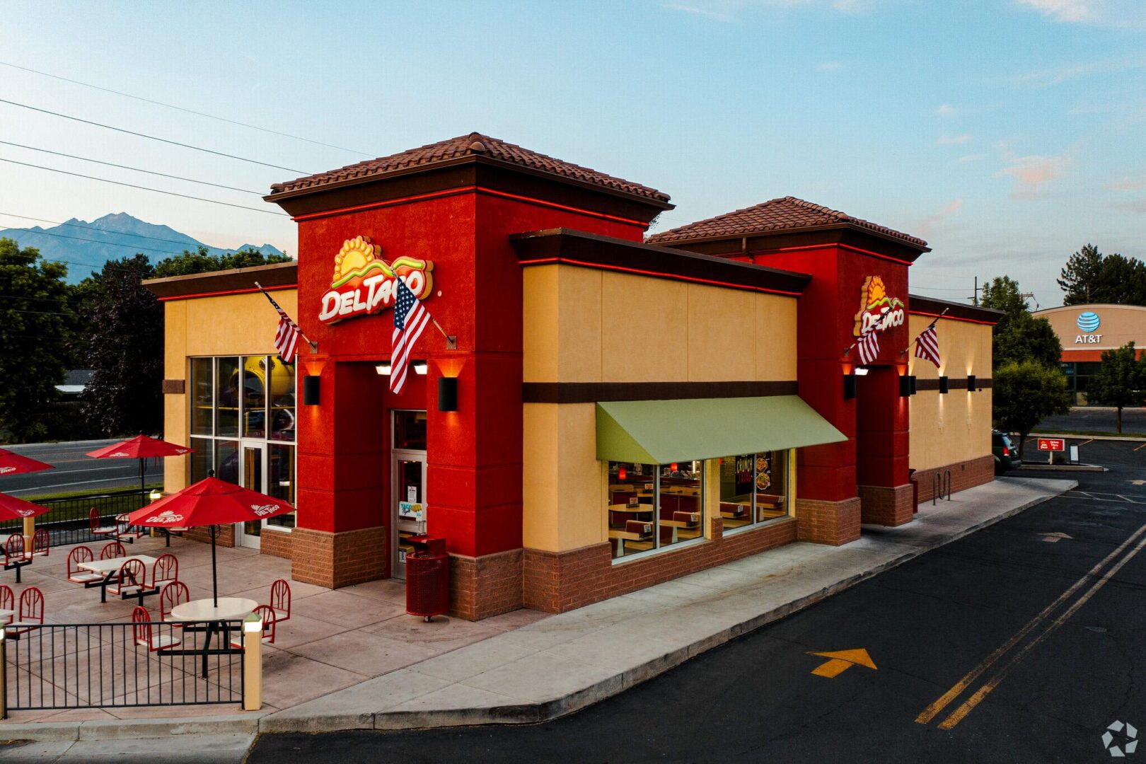 A fast food restaurant with tables and chairs outside.