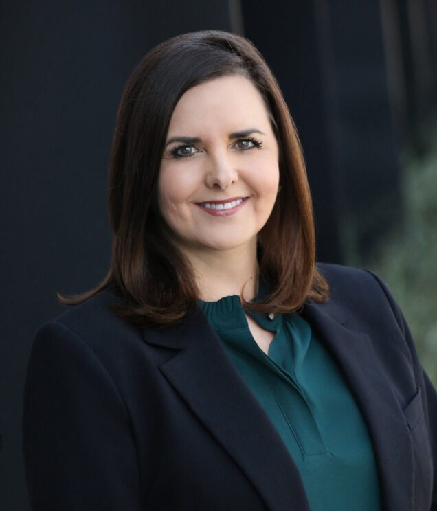 A woman in a black jacket and green shirt