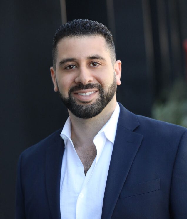 A man in a suit and tie smiling for the camera.