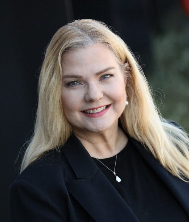 A woman with blonde hair wearing black jacket.