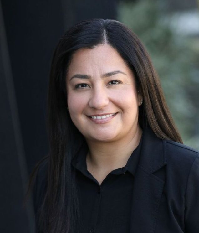 A woman with long black hair wearing a black shirt.