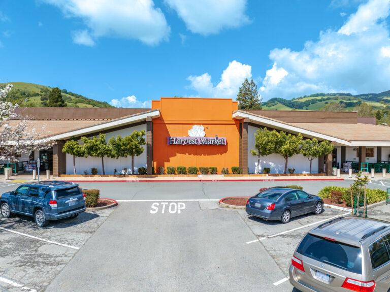 A parking lot with cars parked in front of the building.