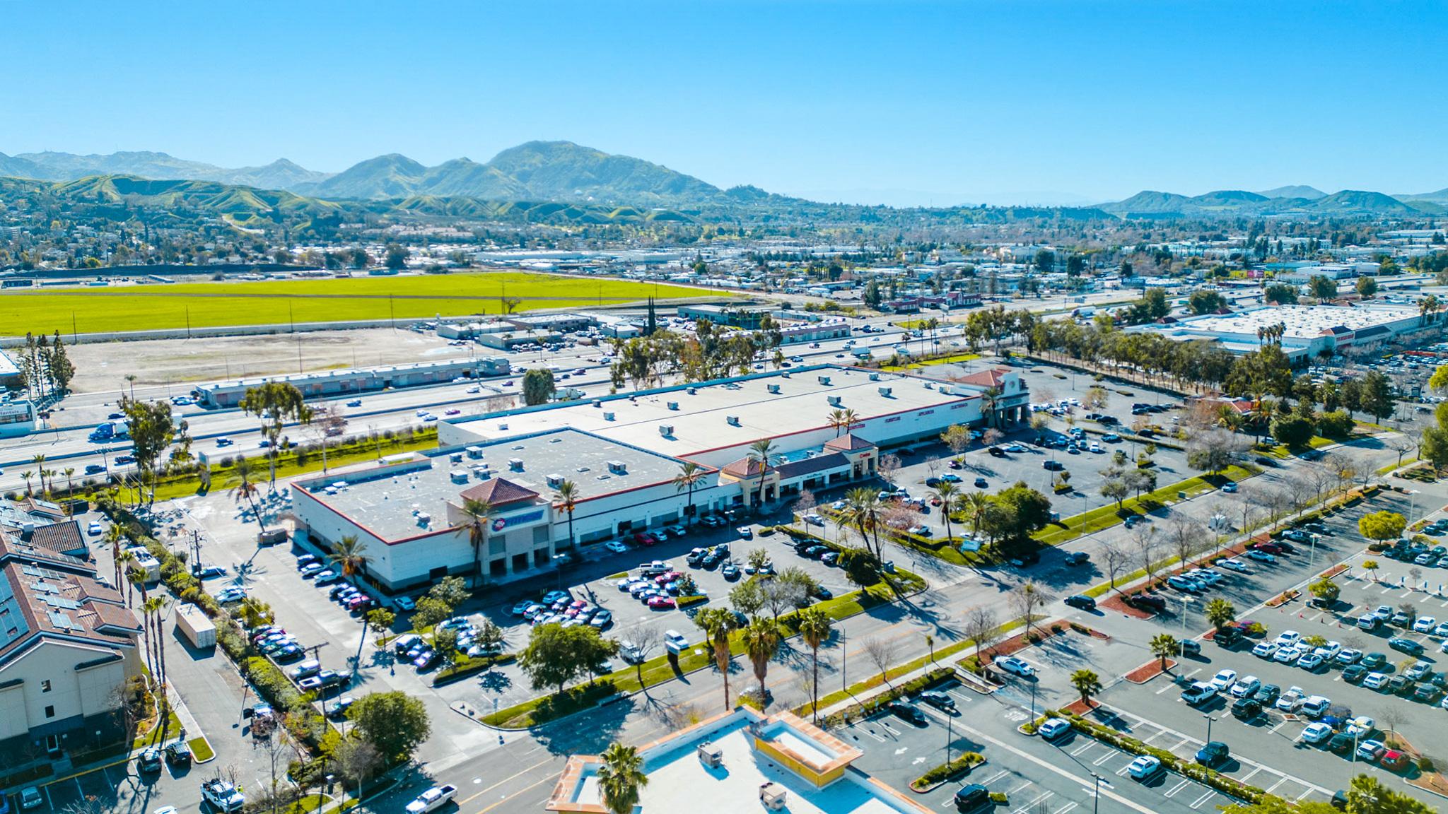 A large shopping center with lots of parking lot.