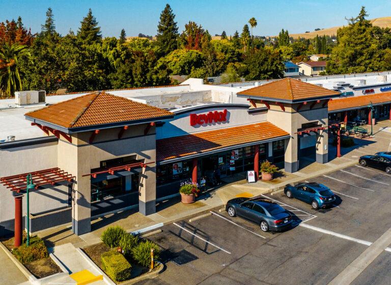 A parking lot with cars parked in front of a restaurant.