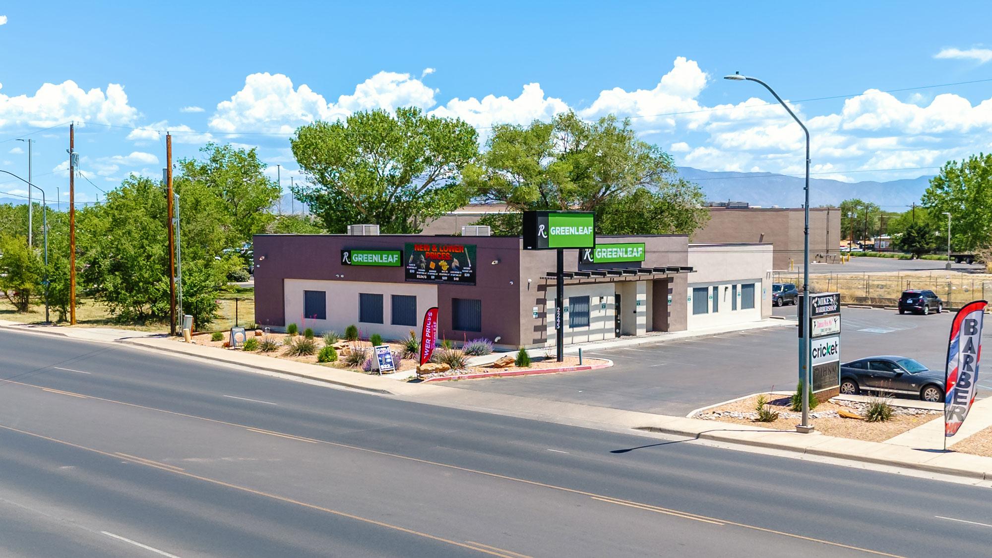 A street view of a motel with cars parked on the side.