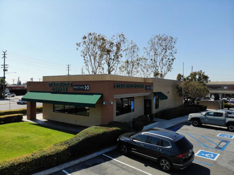 A car parked in front of a building with grass on the roof.